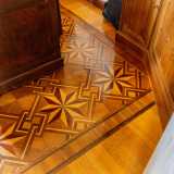 ...sul pavimento invece ammiriamo un incantevole parquet con elaborati decori a stella